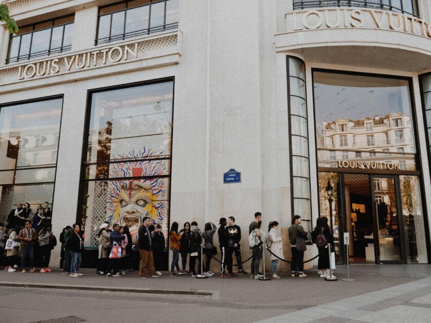 People waiting in line at at a Louis Vuitton store